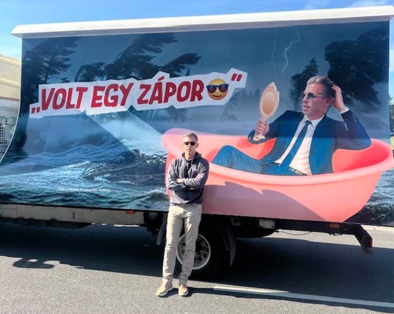 Magyar Péter az őt lejárató plakát előtt pózolt