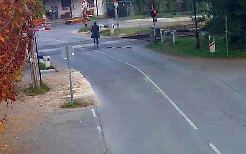 A részeg bringás letörte a sorompót, integetett egyet, majd a száguldó vonat előtt áttekert a síneken – videó