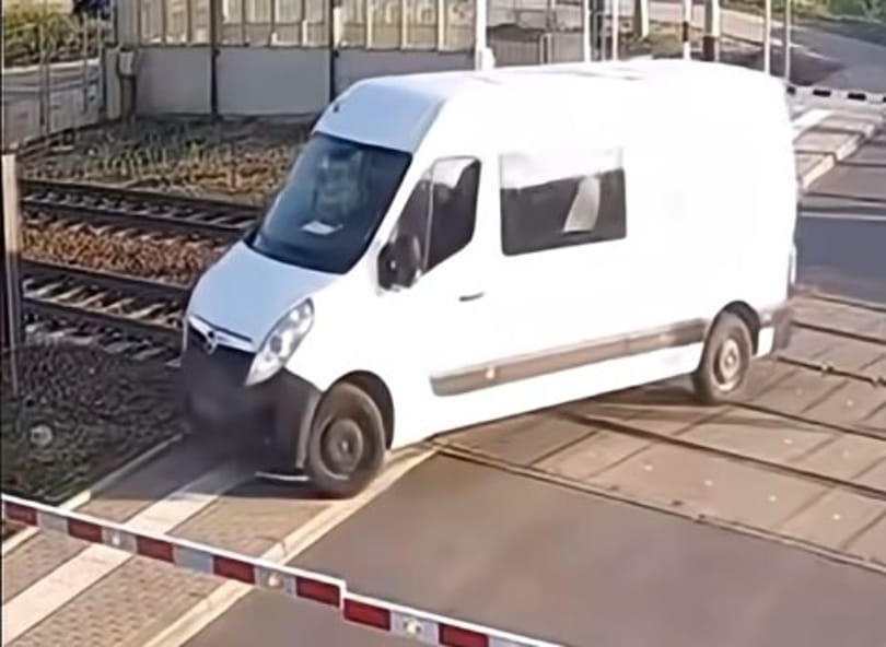 Videón, ahogy száguldó vonat tépi le egy sorompók közé szorult kisbusz hátulját