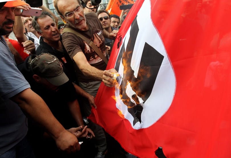 Náci tisztek, égő horogkereszt és meztelen férfi várták Merkelt - Galéria