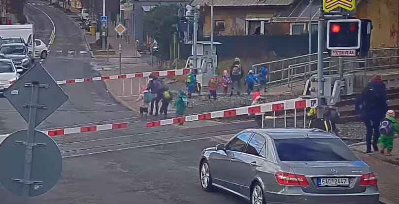 Tilos jelzésénél és lezárt sorompónál vezetik át a síneken az óvodásokat – videó