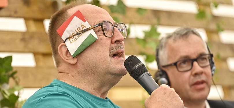 Németh Zsolték Tusványoson szalvétás performance-szal álltak ki a fülön lőtt Trump mellett