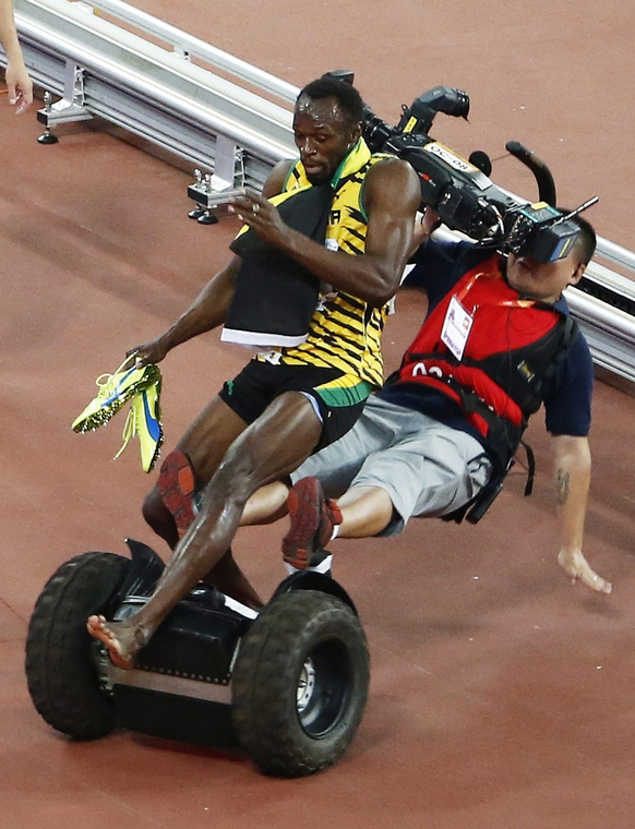 epa.15.08.27. - Peking: Egy operatőr segway-jel gázolta el jamaicai Usain Boltot, miután megnyerte a férfi 200 méteres síkfutás döntőjét a pekingi atlétikai vb-n - Usain Bolt, 7képei, évképei