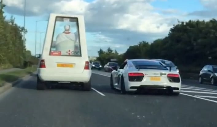 Szokatlanabb páros nem is lehetne, Pápamobil mellett egy Audi R8 az autópályán – videó