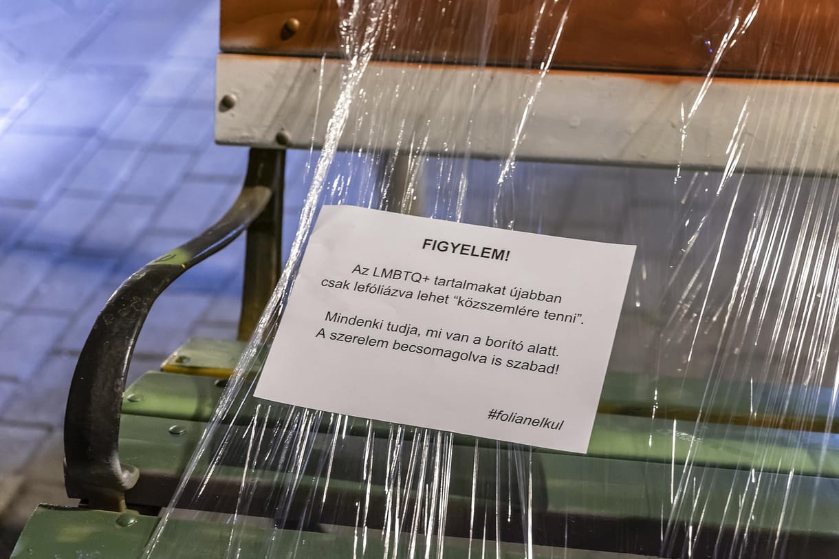 Befóliázták a most épp piros-fehér-zöldre mázolt padot, és ráírták, hogy úgyis tudja mindenki, „mi van a borító alatt