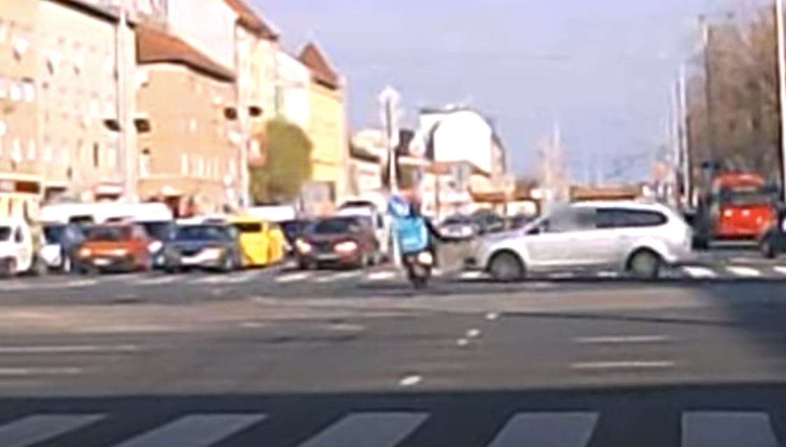 Áthajtott a piroson a budapesti ételfutár, egy autó oldalának csapódott – videó