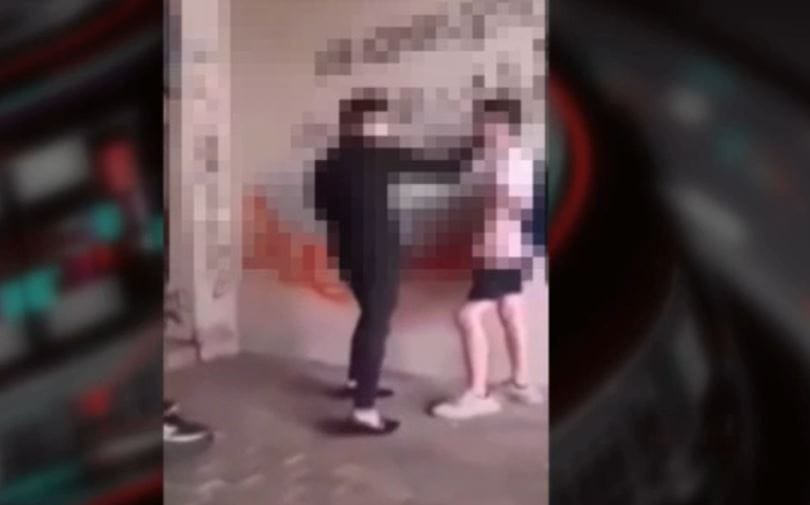 Videón, ahogyan egy fiút addig pofoz egy kamasz, amíg az le nem térdel neki