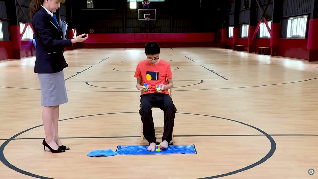 Ez a kínai fiú egyszerre három Rubik-kockát rakott ki, az egyikhez még a kezét sem használta – videó