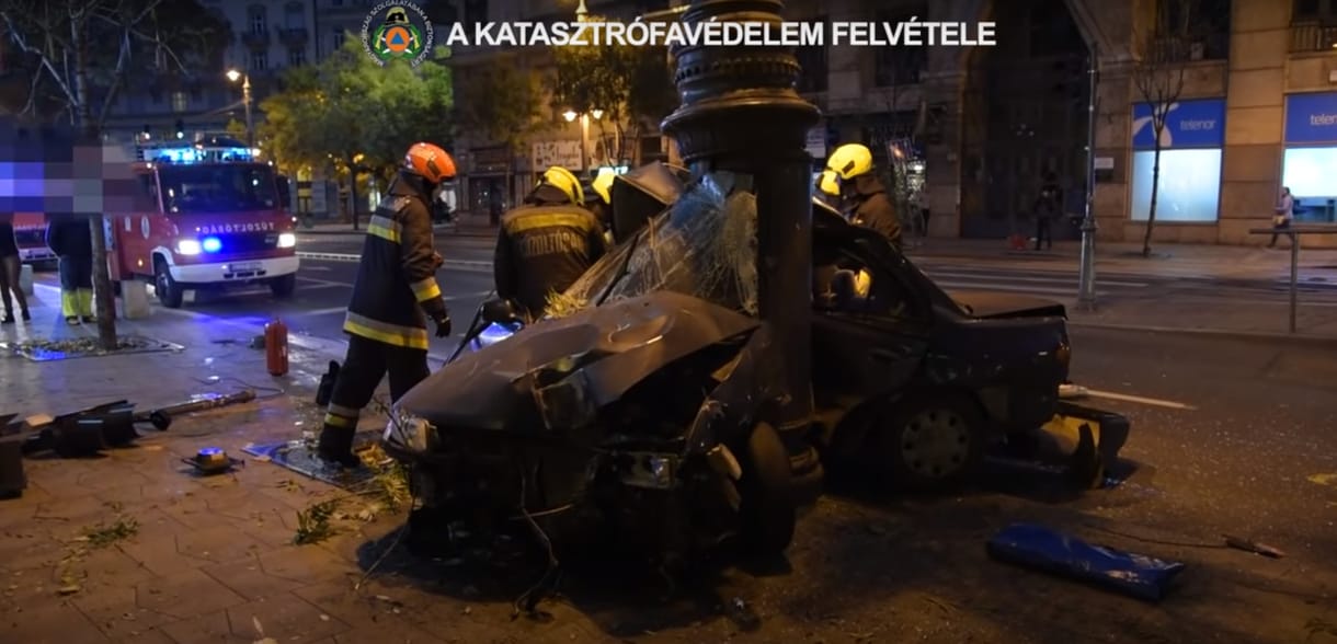 Videó: A katasztrófavédelem küszködik a Kiskörúton oszlopra csavarodott autó roncsával