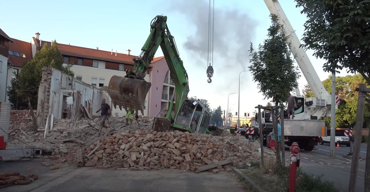 Videón, ahogy kiszabadítják a pincébe zuhant 20 tonnás markolót Szombathelyen
