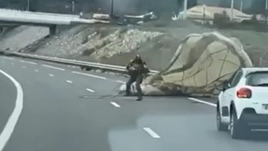 Ejtőernyős katonát sodort a szél egy autópályára – videó
