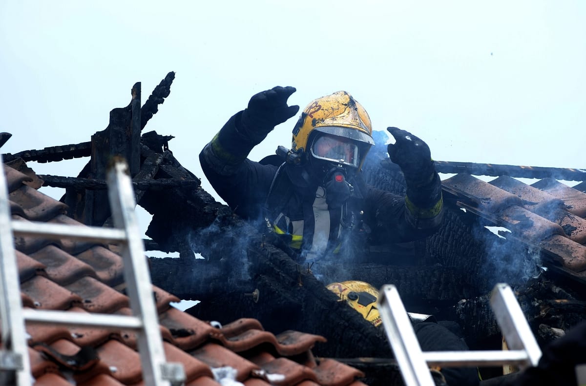 Kigyulladt egy társasház tetőszerkezete, a lakók az utcán csoportosulnak