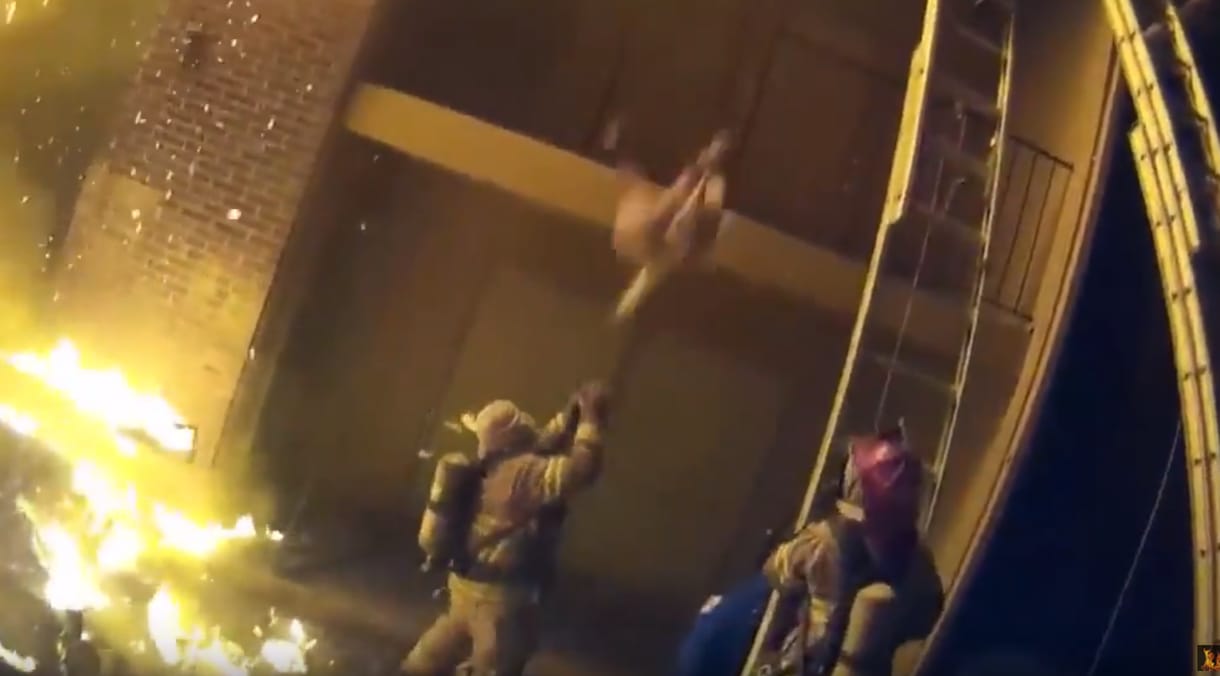Drámai videón, ahogy egy tűzoltó elkapja a lángoló házból kimentett gyereket