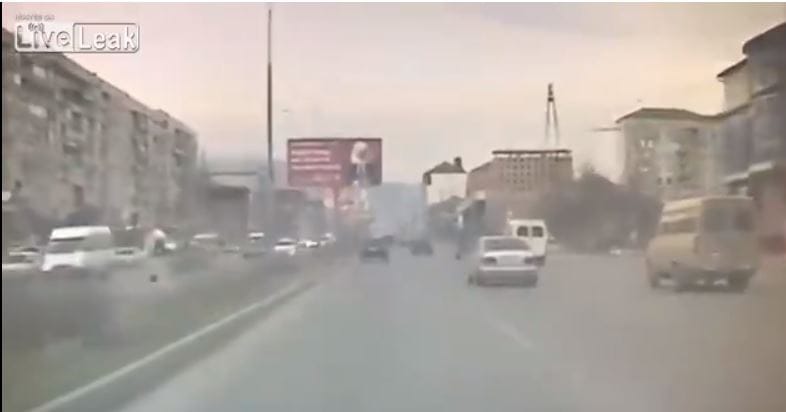 Erre azért mégse számíthat: az óriásplakát vágja kupán az autót – videó