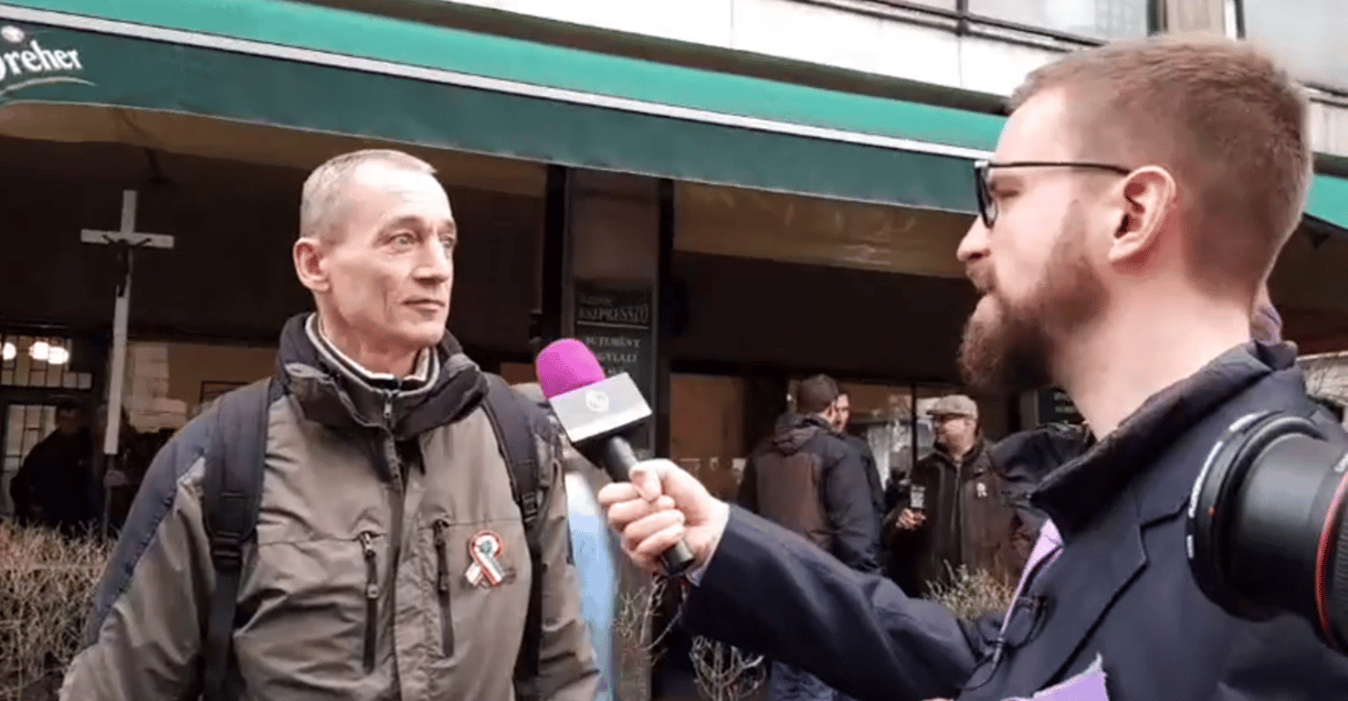 Gulyás Márton kerítésszaggató pálinkával kínálja a CÖF-menet tüntetőit