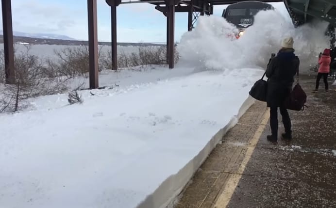 Egy érkező vonat durván beborította a peronon várakozó utasokat hóval