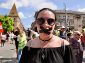 Leragasztott szájjal vonulnak át a tüntetők a Szabadság hídon