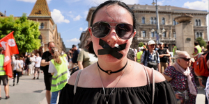 Leragasztott szájjal vonulnak át a tüntetők a Szabadság hídon