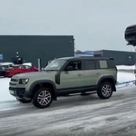 A kereskedés előtt álló vadonatúj Land Rover Defender húzta ki a bajból az autószállító kamiont – videó