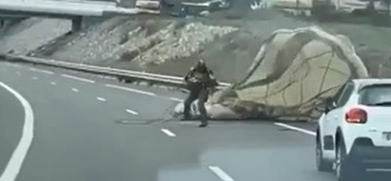Ejtőernyős katonát sodort a szél egy autópályára – videó