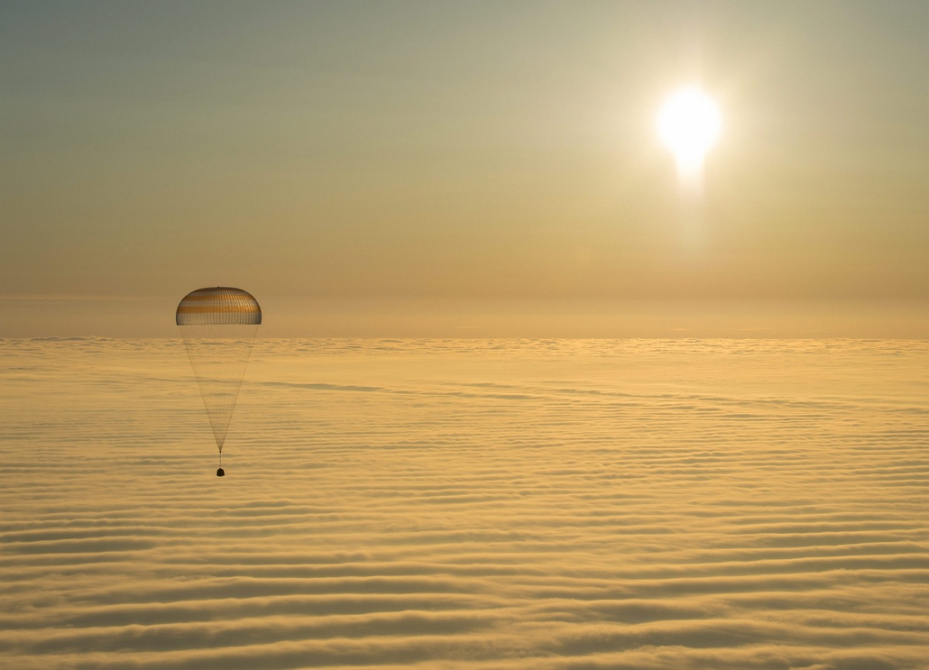 afp.15.03.12. - Dzsezkazgan - A NASA által közreadott felvételen a Szojuz TMA-14M orosz űrhajó ejtőernyővel fékezett leszállóegysége földet ér a kazahsztáni Dzsezkazgan várostól délkeletre 2015. március 